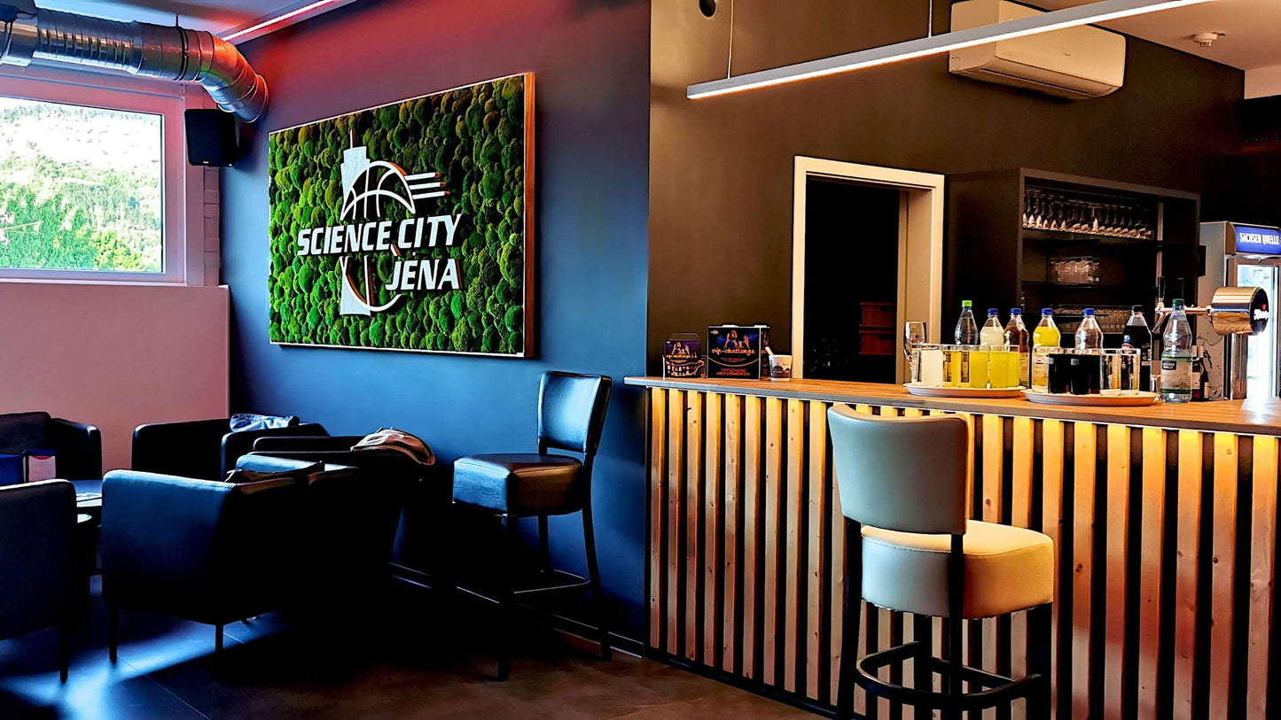Moosbild mit Firmenlogo aus Fichte und Eiche in einer VIP Lounge mit Bar