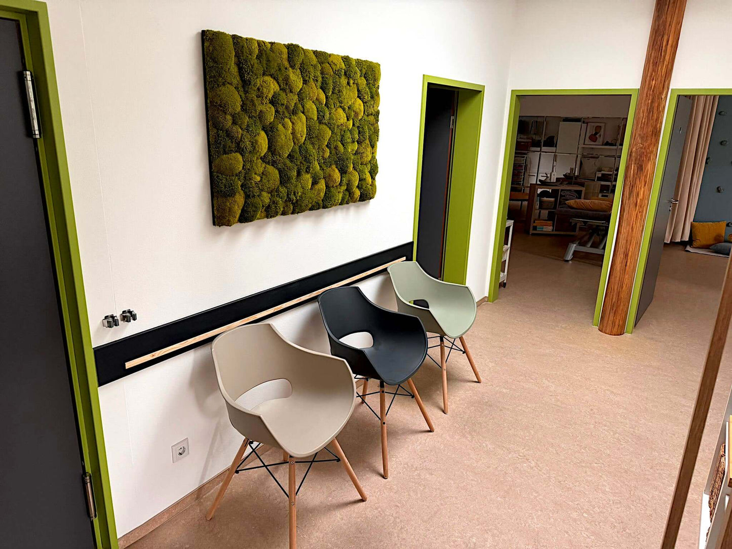 Moosbild "Natur Pur" in modernem Raum mit Stühlen, vereint Kugel- und Provence Moose für natürliche Eleganz.