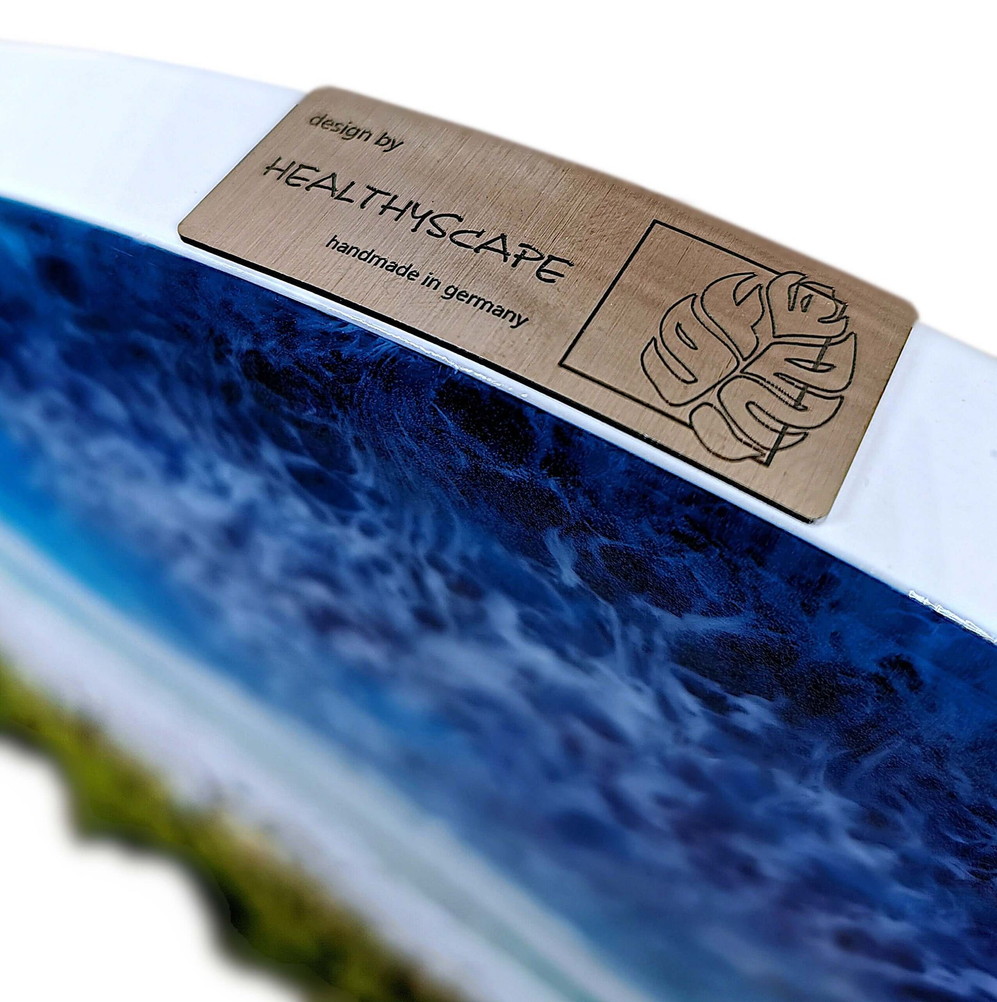 Design plaque of handcrafted art piece by HealthyScape featuring ocean waves and coastal scenery.