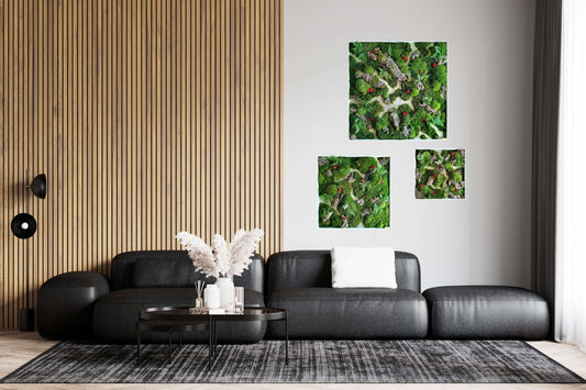 Quadratisches Moosbild "Red Aronia" in modernem Wohnzimmer mit schwarzem Sofa und Holzpaneelen.